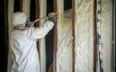 Technician spraying foam.