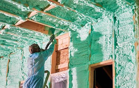 Technician spraying insulation in a building.